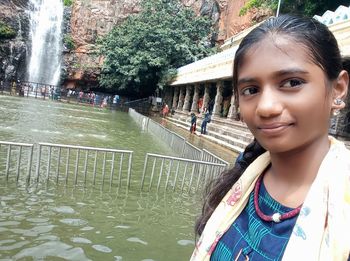 Portrait of smiling woman standing by water