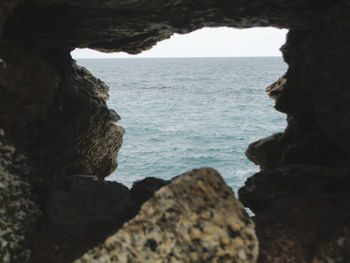 Rock formation on beach against sky