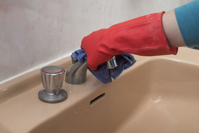 Cleaning pipe in bathroom with gloves to mean a concept