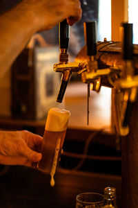Midsection of man preparing beer in bar