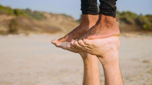 Low section of man standing on beach