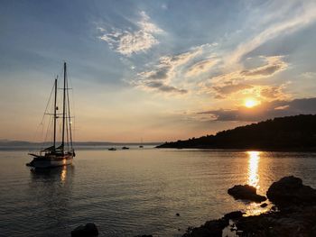 Sailboat in sea against sky during sunset