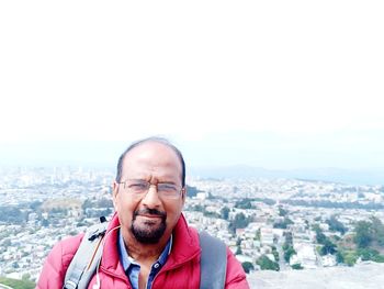 Portrait of man in city against sky