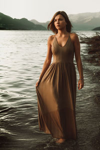 Portrait of woman standing at sea shore