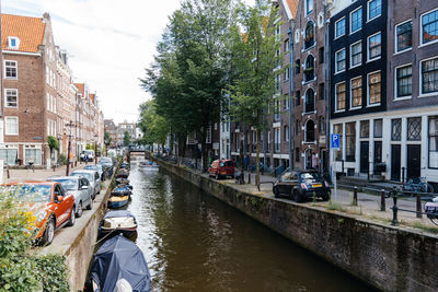 High angle view of boats moored in canal amidst buildings in city