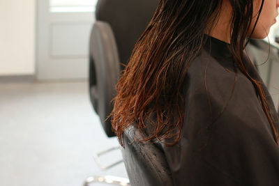 Rear view of woman standing against wall