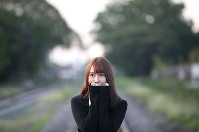 Portrait of woman standing against blurred background