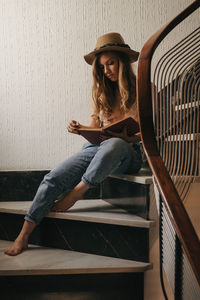 Portrait of woman sitting against wall