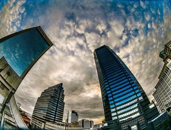 Low angle view of buildings against cloudy sky