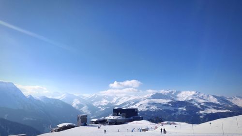 Scenic view of snowcapped mountains against blue sky