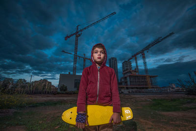 Portrait of teenage girl sitting on land against sky