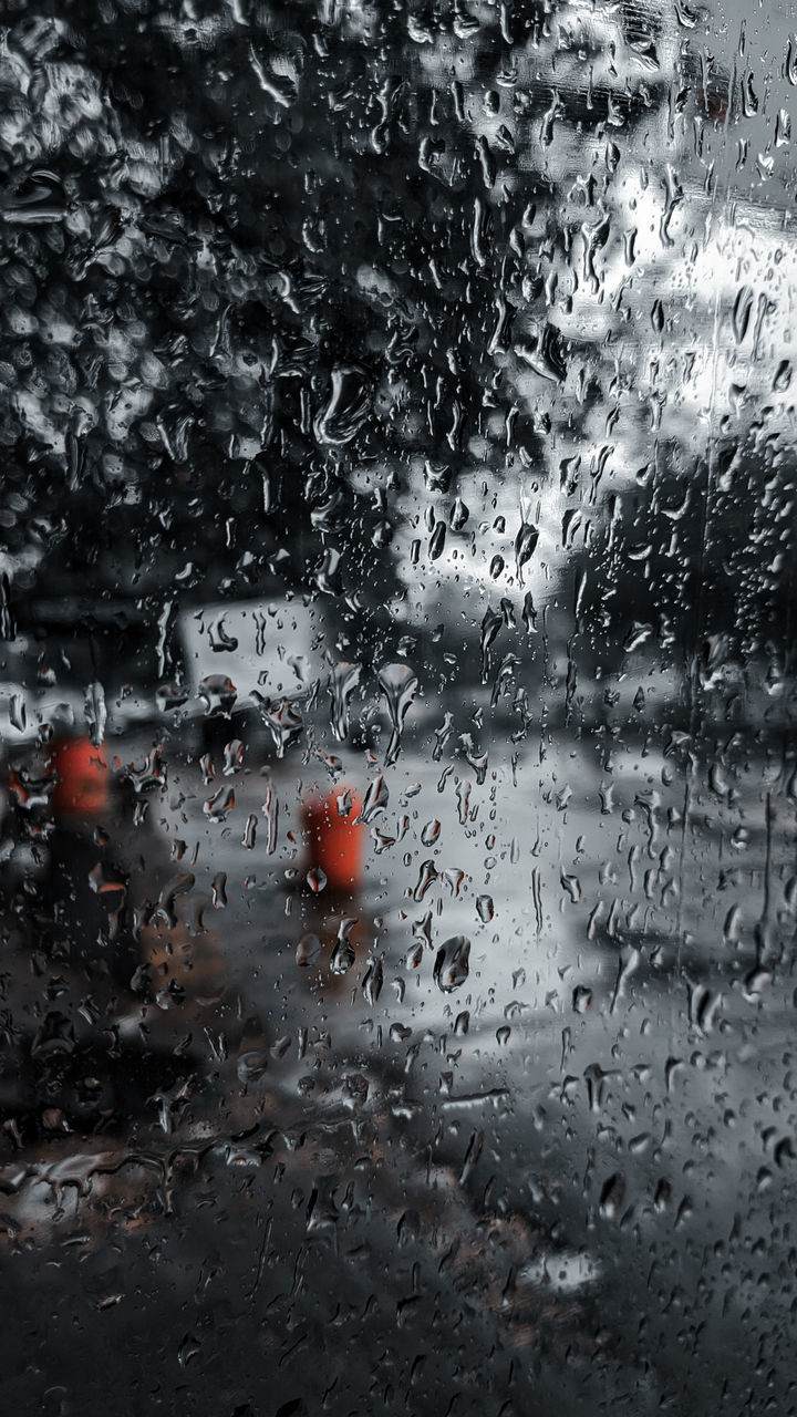 RAINDROPS ON GLASS WINDOW OF RAINY SEASON