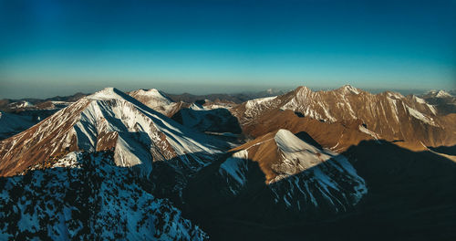 Scenic view of snowcapped mountains against blue sky