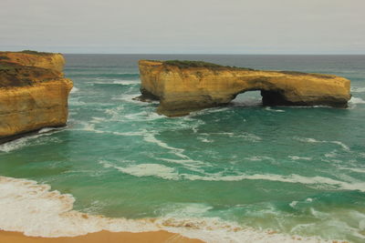 Rock formation in sea against clear sky