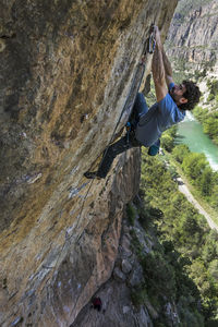 High angle view of man climbing on rock