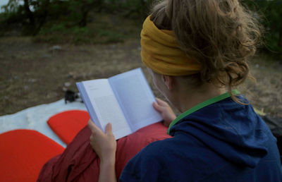 Woman reading book in camp