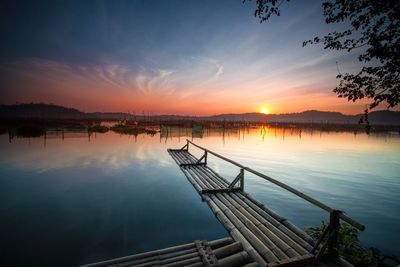 Scenic view of lake against sky at sunset