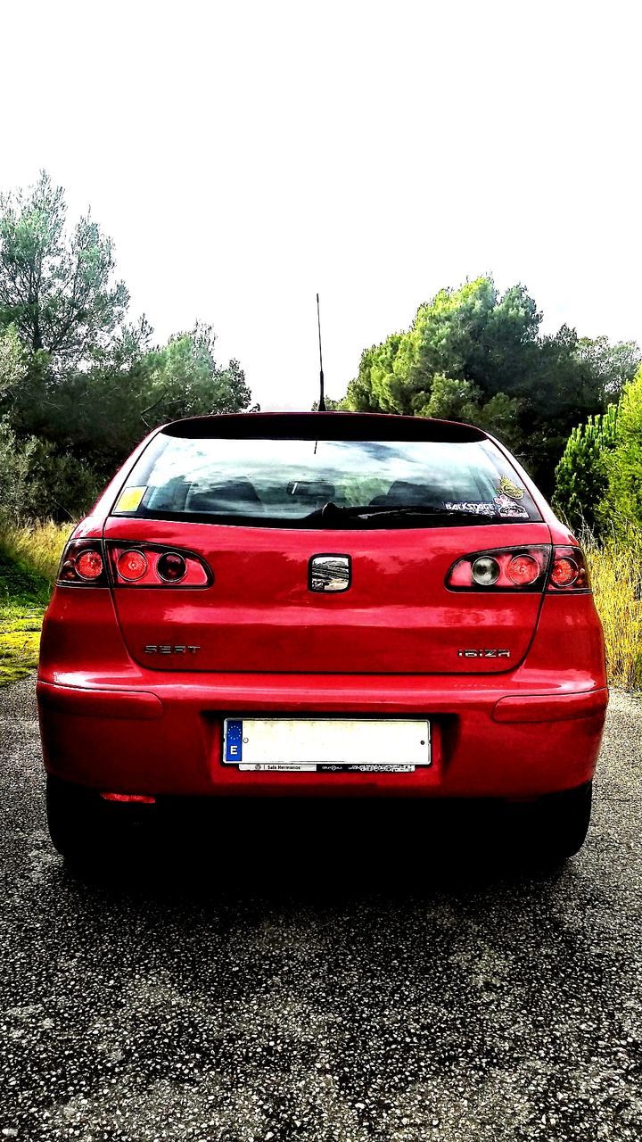 RED CAR ON ROAD IN CITY