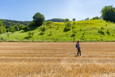 Full length of woman standing on field against sky