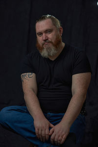 Portrait of senior man sitting on sofa at home