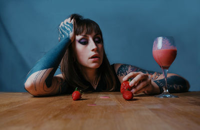 Portrait of young woman sitting on table