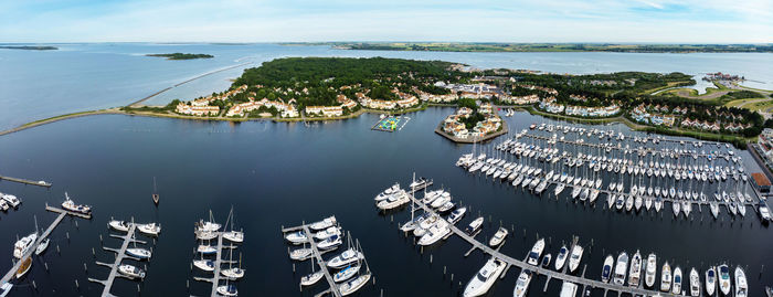 High angle view of sailboats moored in sea against sky