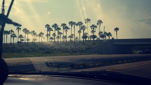 Cars on road against cloudy sky