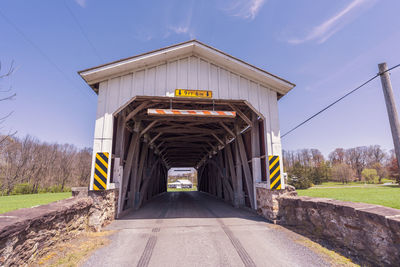 Road leading towards bridge against sky