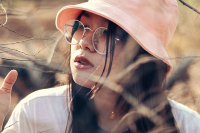 Close-up of young woman wearing hat outdoors