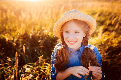 Smiling girl looking away against plants