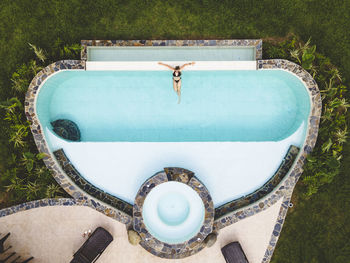 Top view woman alone in a swimming pool enjoying a sunny summer day