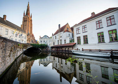 Boat moored on canal amidst buildings