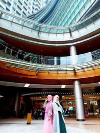 Low angle view of woman standing against building