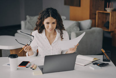 Young woman using laptop at table