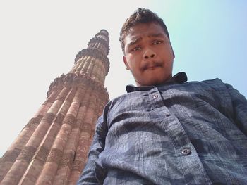 Low angle view of boy on cross against sky