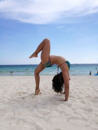 Full length of woman on beach against sky