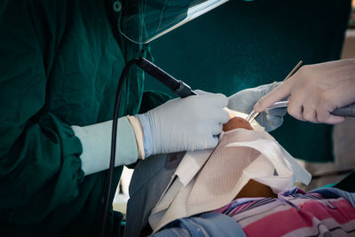 Dentists operating male patient in office