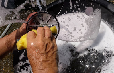 Cropped hands of person washing equipment