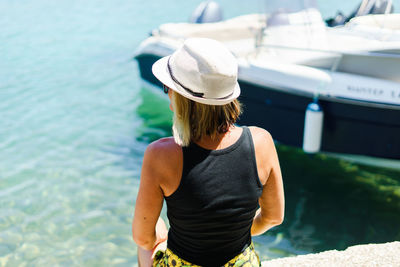 Rear view of woman sitting at sea