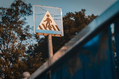 Low angle view of road sign against trees