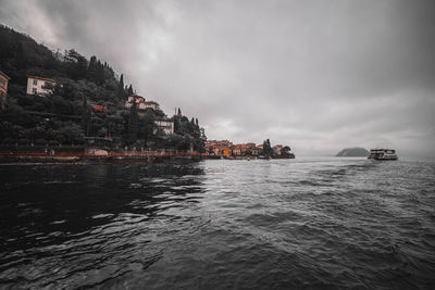 Scenic view of sea by buildings against sky