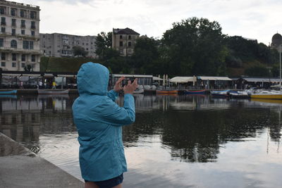 Reflection of  a woman photographing in lake