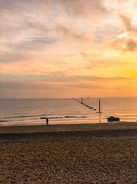 Scenic view of sea against cloudy sky during sunset