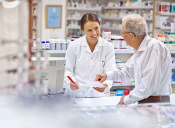 Man pointing at prescription held by pharmacist