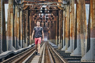 Man walking on railway bridge