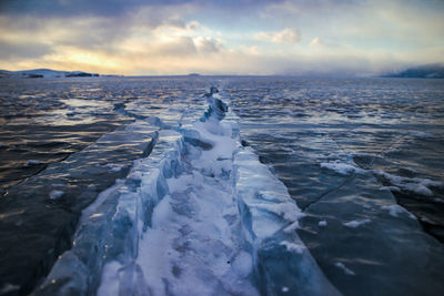 Scenic view of frozen sea against sky during sunset