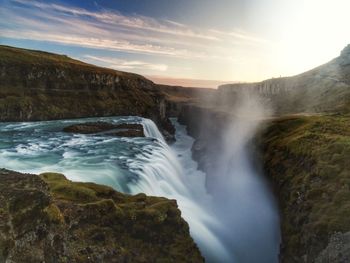 Scenic view of waterfall against sky