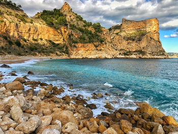 Scenic view of rocks in sea against sky