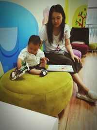 Mother and daughter playing sitting at home