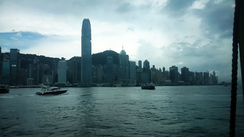 Boats sailing in sea with city in background